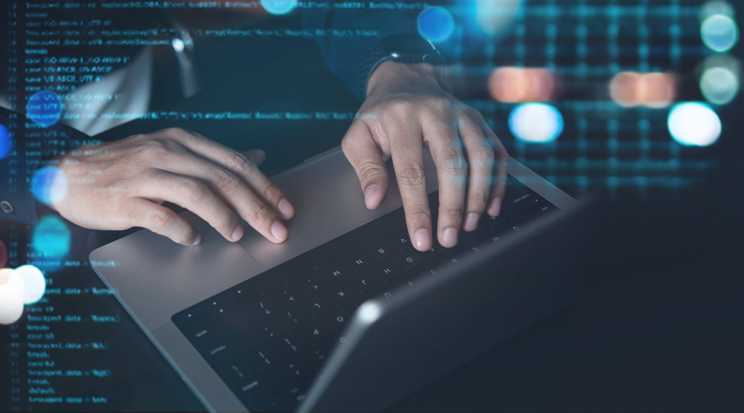 Man with hands on laptop - coding with AI