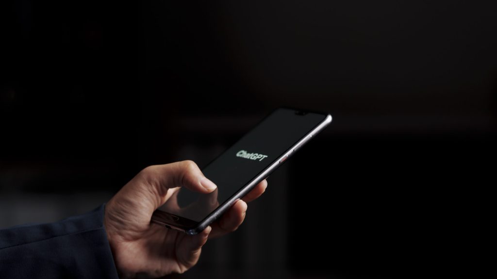 User with phone, searching the internet using ChatGPT