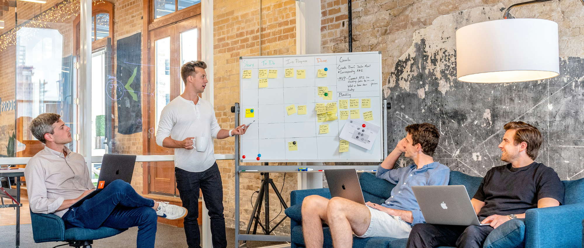 men talking by whiteboard and with computers planning potential ai project